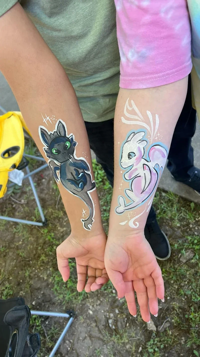 A painted dragon and unicorn on two children’s forearms