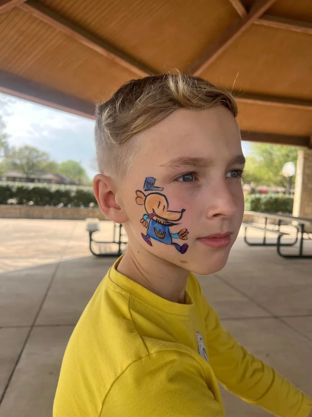 A boy with a cartoon character painted on his cheek